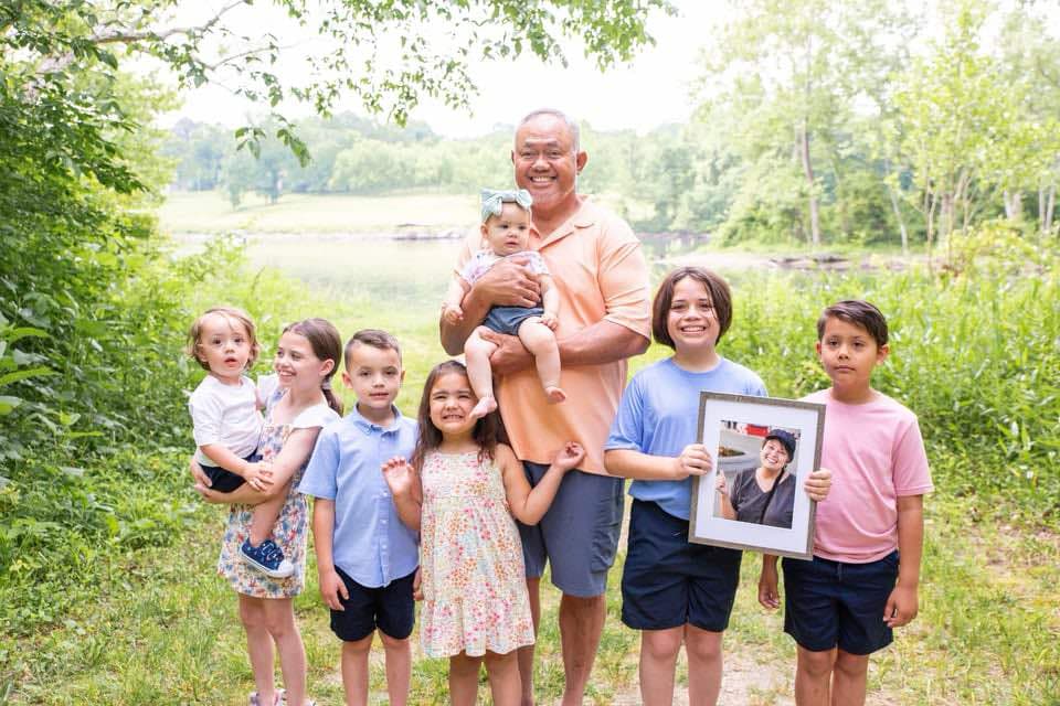 Grandfather with his grandchildren holding a framed image of the recently departed wife / grandmother